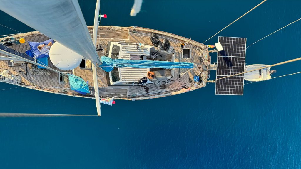 Luftaufnahme des Teakdecks mit Solarpanel und Dinghy